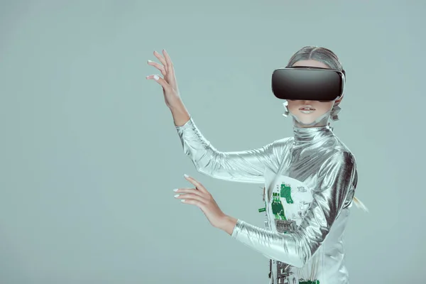 Silver robot touching something with virtual reality headset isolated on grey, future technology concept — Stock Photo