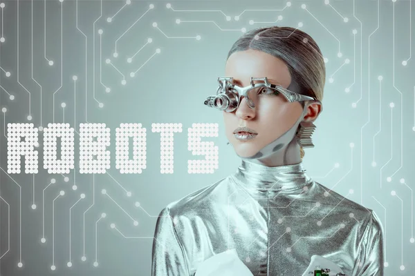 Cyborg plateado futurista mirando hacia otro lado aislado en gris con letras 