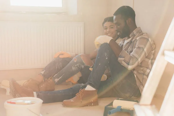Красива молода пара розслабляється на підлозі при ремонті будинку — стокове фото