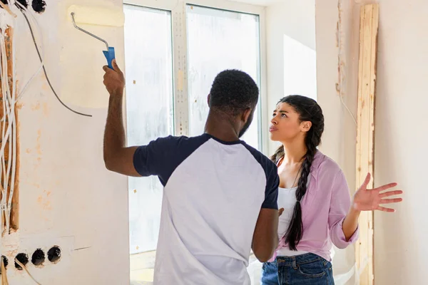 Young couple having quarrel while making renovation of home — Stock Photo