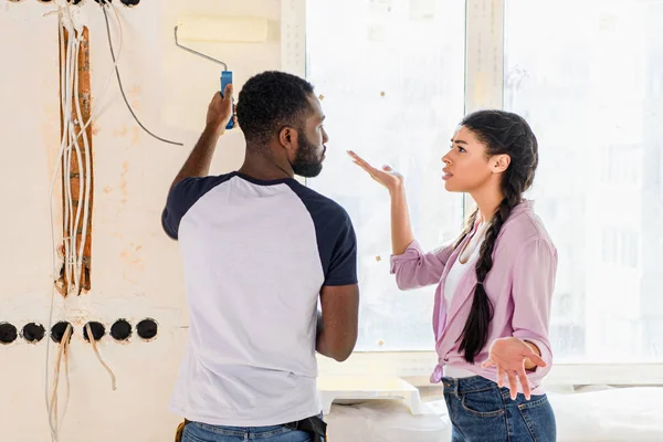 Couple afro-américain avoir querelle tout en faisant la rénovation de la maison — Photo de stock