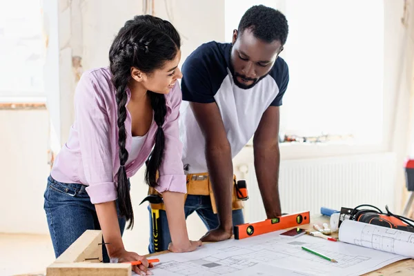 Young couple with architecture plan making renovation of home together — Stock Photo