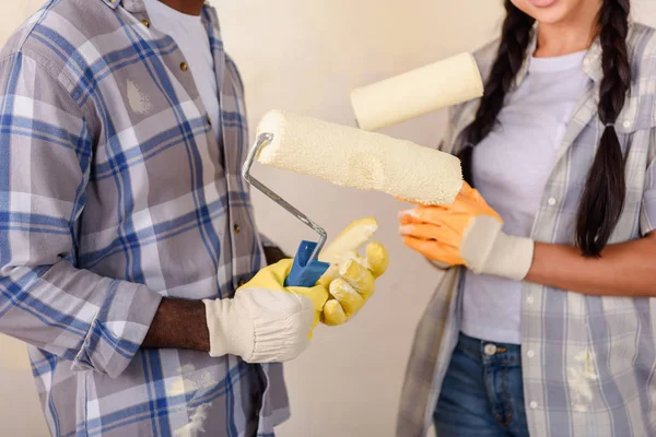 Cropped shot of couple holding rolling brushes while making renovation of home — Stock Photo