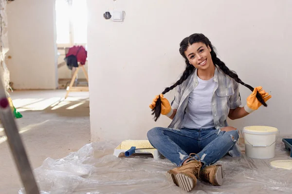 Красивая молодая женщина сидит на полу во время ремонта дома — стоковое фото