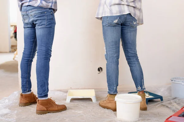 Imagen recortada de pareja de pie cerca de la pared pintada durante la renovación en el nuevo hogar - foto de stock