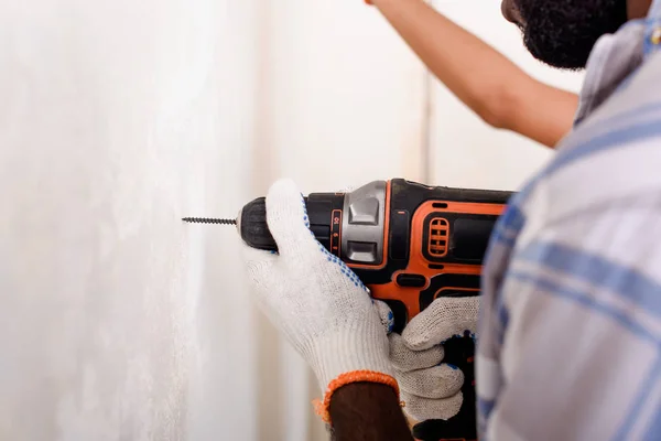 Cropped image of man in protective gloves working with power drill — Stock Photo