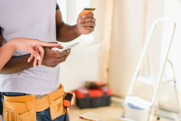 Immagine ritagliata di donna che punta il dito sullo smartphone mentre il suo ragazzo in piedi vicino con carta di credito — Foto stock