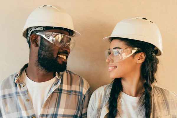 Happy african american couple in protective helmets and gogges looking at each other — Stock Photo