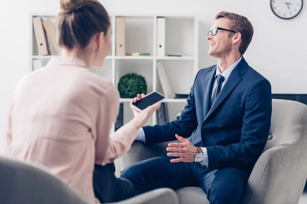 Lachender gutaussehender Geschäftsmann gibt Journalisten im Amt ein Interview — Stockfoto