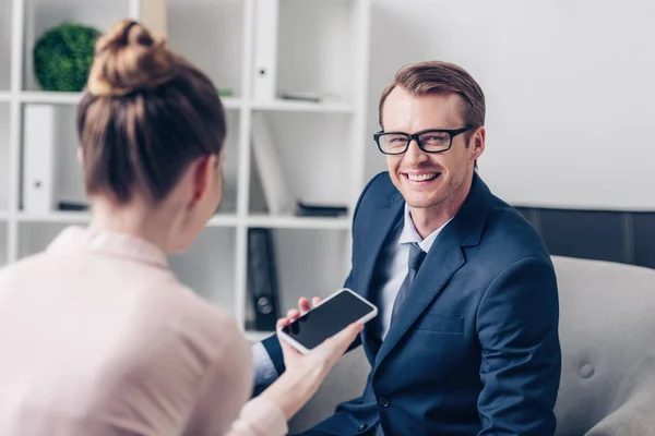 Homme d'affaires beau et souriant donnant une interview à un journaliste en fonction — Photo de stock