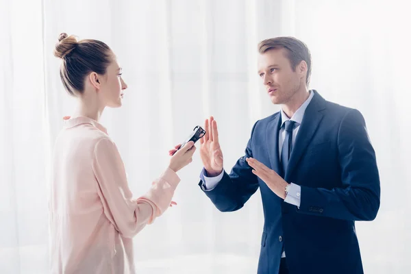 Handsome businessman rejecting giving interview to journalist with voice recorder in office — Stock Photo