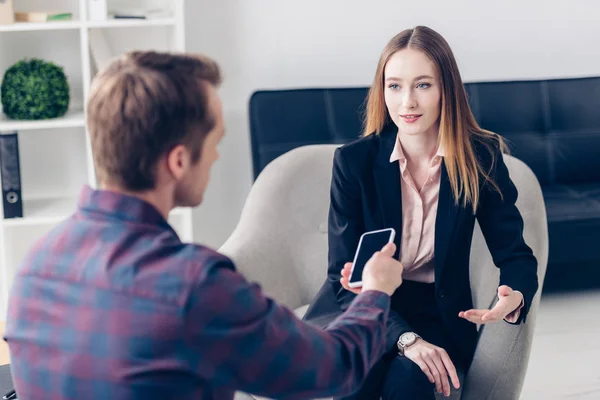 Jeune belle femme d'affaires en costume donnant une interview au journaliste en fonction — Photo de stock