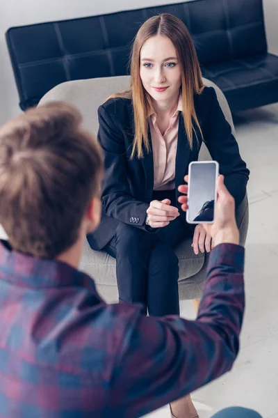 Vue grand angle de journaliste enregistrement interview avec femme d'affaires sur smartphone dans le bureau — Photo de stock