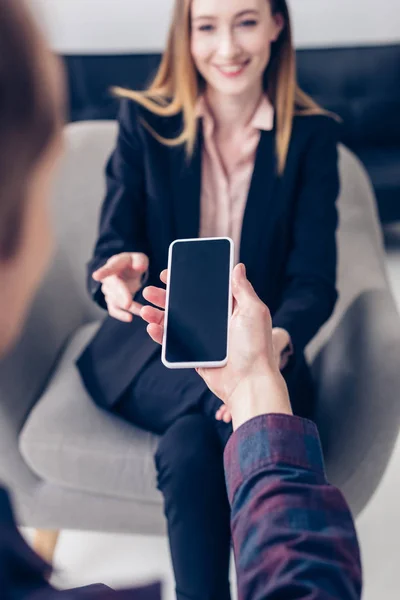 Enfoque selectivo de la entrevista de grabación de periodistas con empresaria en el teléfono inteligente en la oficina - foto de stock