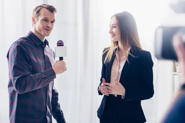 Hermosa mujer de negocios en traje dando entrevista a periodista en la oficina - foto de stock