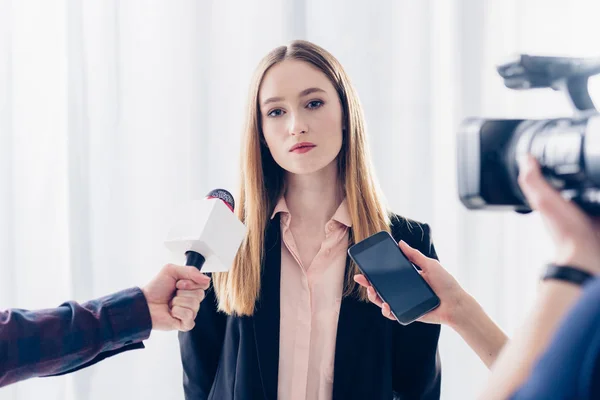 Atractiva mujer de negocios dando entrevista a periodistas en el cargo - foto de stock