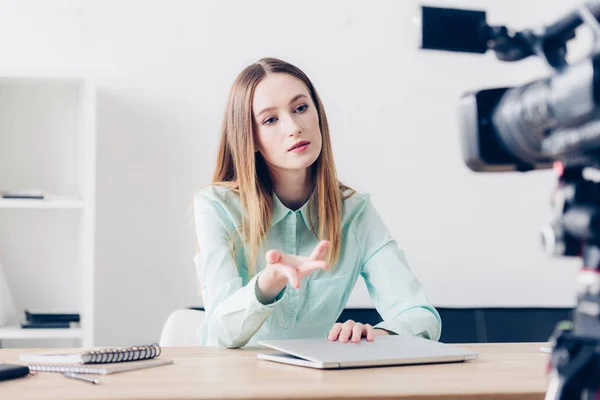 Jornalista feminino atraente gravação de vídeo blog e gestos no escritório — Fotografia de Stock