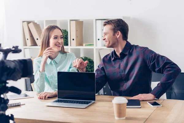 Smiling video bloggers recording vlog in office and looking at each other — Stock Photo