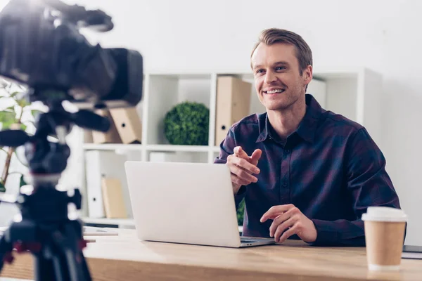 Smiling handsome male video blogger in violet shirt recording video blog in office — Stock Photo