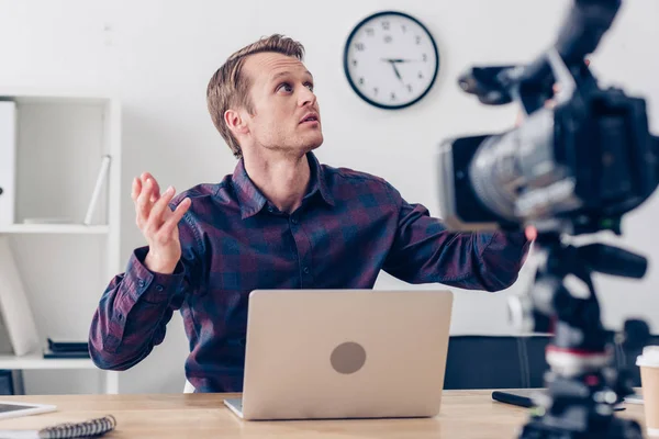 Shocked handsome male video blogger recording vlog and looking up in office — Stock Photo