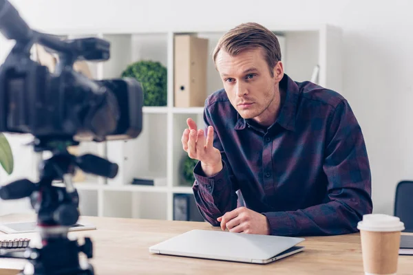 Irritated male video blogger recording vlog and gesturing in office — Stock Photo