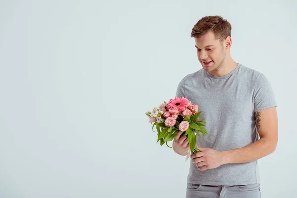 Handsome man holding pink flower bouquet with copy space isolated on grey — Stock Photo