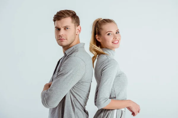 Serious man and beautiful smiling woman posing together isolated on grey — Stock Photo