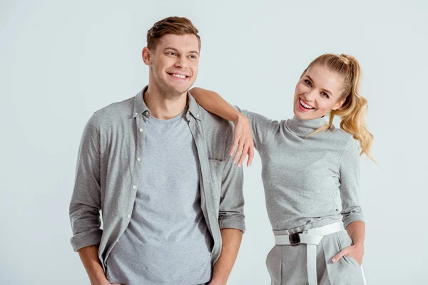 Hermosa pareja sonriente mirando a la cámara y posando aislados en gris - foto de stock