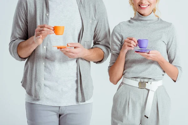 Cropped view of couple holding colorful coffee cups isolated on grey — Stock Photo