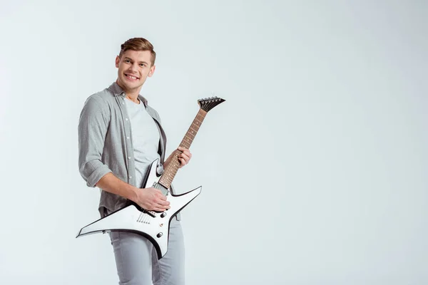 Animado bonito homem em roupas cinza tocando guitarra elétrica isolada em cinza — Fotografia de Stock