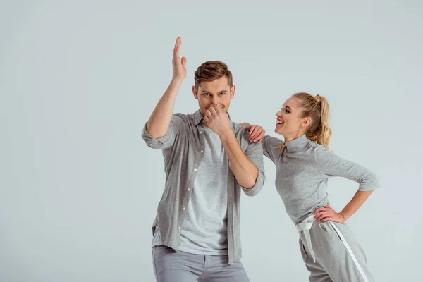 Pareja divirtiéndose y hombre haciendo natación danza movimiento aislado en gris - foto de stock