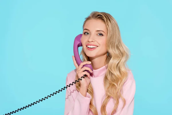 Красивая женщина говорит по старинному телефону с бирюзовым фоном — стоковое фото