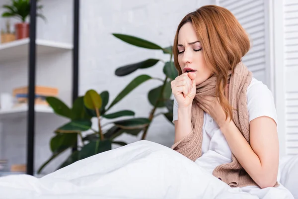 Sick woman coughing and touching throat at home — Stock Photo