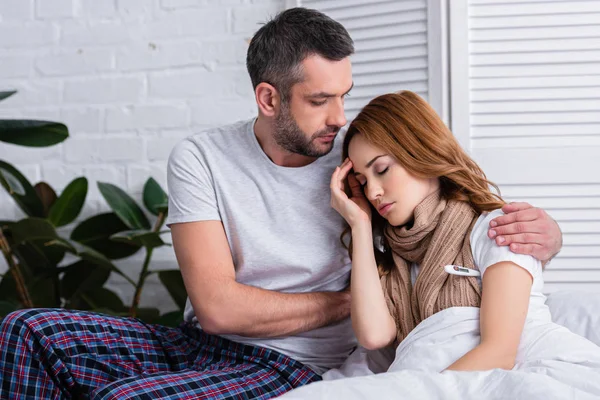 Schöner Freund umarmt kranke Freundin im Schlafzimmer — Stockfoto