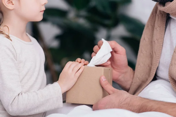 Abgeschnittenes Bild von Tochter, die kranken Vater Servietten im Schlafzimmer schenkt — Stockfoto