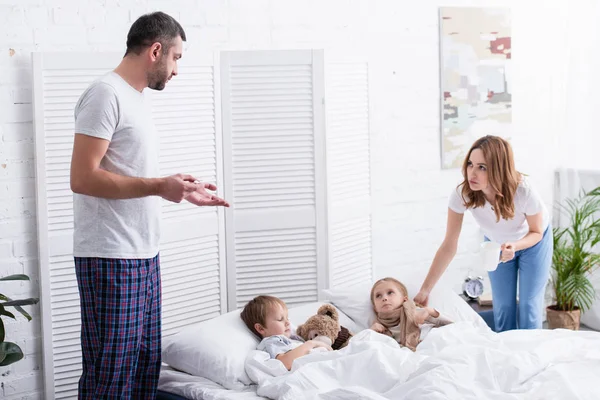 Eltern kümmern sich um kranke Vorschulkinder im Schlafzimmer — Stockfoto