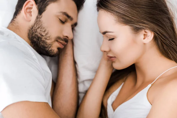 Close up of attractive couple sleeping together in white bed — Stock Photo