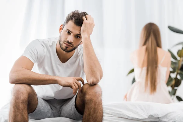Chateado homem com problemas sexuais sentado na cama com a namorada — Fotografia de Stock