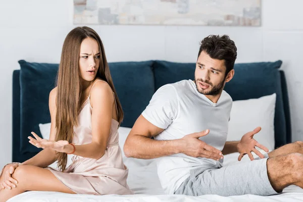 Junges Paar streitet und hat sexuelle Probleme, während es auf dem Bett sitzt — Stockfoto