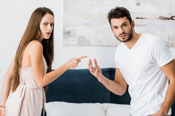 Young attractive woman pointing with finger angrily at man — Stock Photo