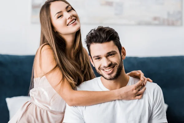 Молодая счастливая женщина обнимает парня и улыбается — стоковое фото