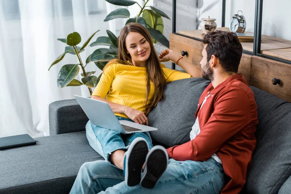 Young attractive girl resting with laptop and looking at boyfriend — Stock Photo