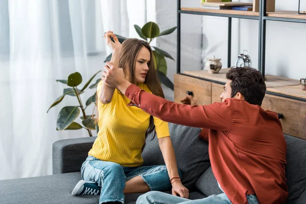 Angry woman fighting with boyfriend on sofa in living room — Stock Photo
