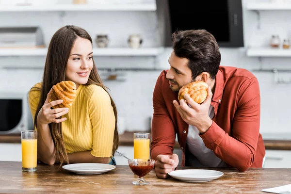 Selective focus of happy couple having breakfast in kitchen — Stock Photo