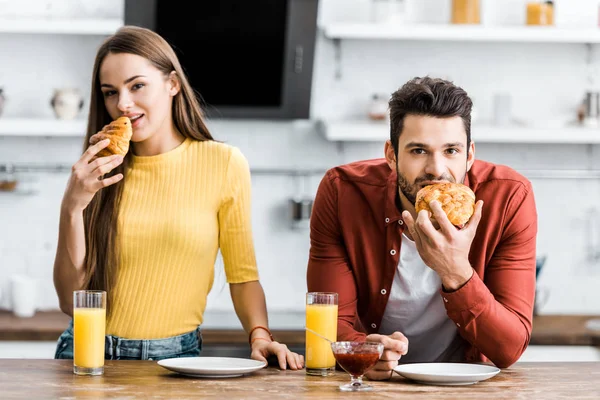 Selective focus of happy couple eating breakfast in kitchen — Stock Photo