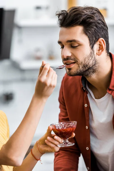 Foco seletivo da mulher alimentando namorado com geléia — Fotografia de Stock