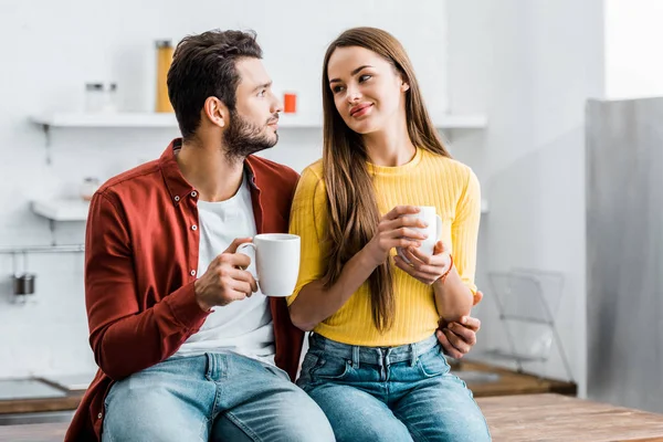 Mujer feliz mirando novio y sosteniendo taza - foto de stock