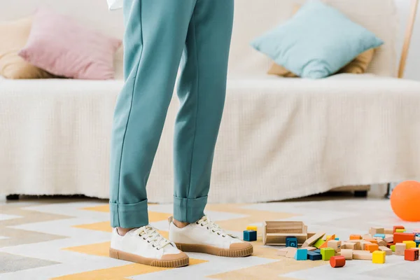 Cropped view of woman standing near multicolored wooden cubes — Stock Photo