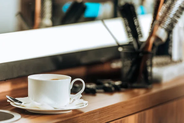 Nahaufnahme der Tasse Kaffee und professionelle Friseur-Tools im Schönheitssalon — Stockfoto