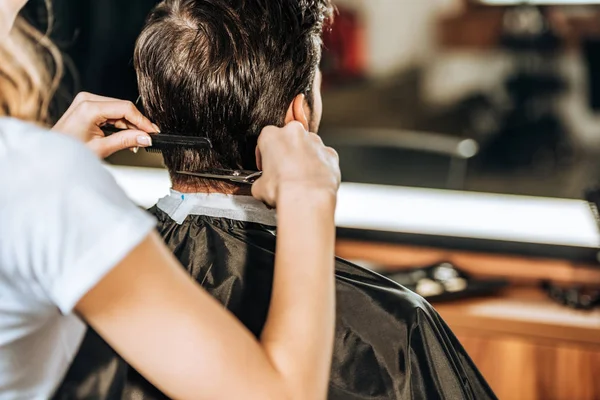 Recortado tiro de peluquero corte de pelo para el cliente masculino en salón de belleza - foto de stock